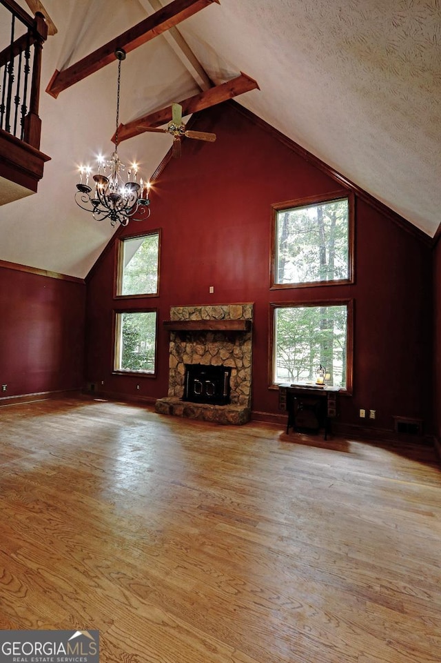 4393 Cannon Rd, Loganville, GA 30052 - unfurnished living room featuring high vaulted ceiling, a chandelier, wood finished floors, beamed ceiling, and a stone fireplace