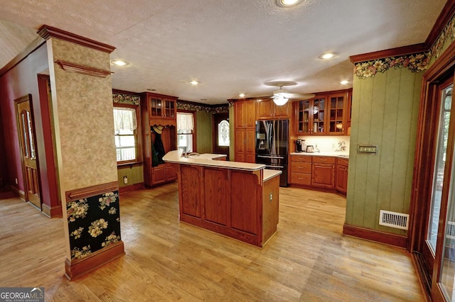 4393 Cannon Rd, Loganville, GA 30052 - kitchen with fridge with ice dispenser, light wood-style floors, brown cabinets, glass insert cabinets, and crown molding
