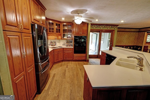 4393 Cannon Rd, Loganville, GA 30052 - kitchen featuring black appliances, brown cabinetry, light wood finished floors, light countertops, and a ceiling fan
