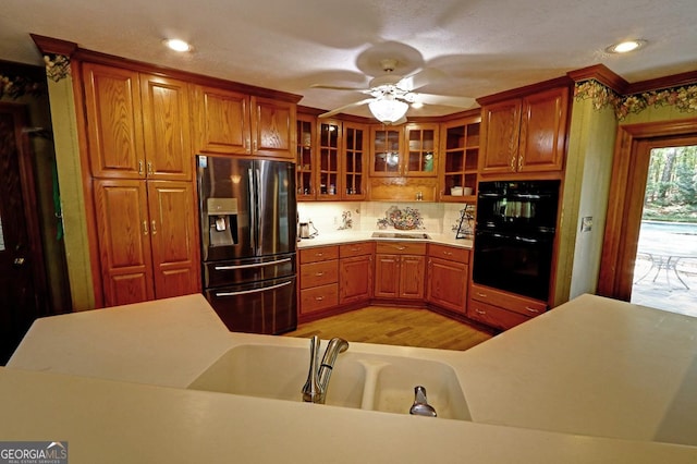 4393 Cannon Rd, Loganville, GA 30052 - kitchen featuring stainless steel fridge with ice dispenser, brown cabinets, decorative backsplash, glass insert cabinets, and light wood-style floors