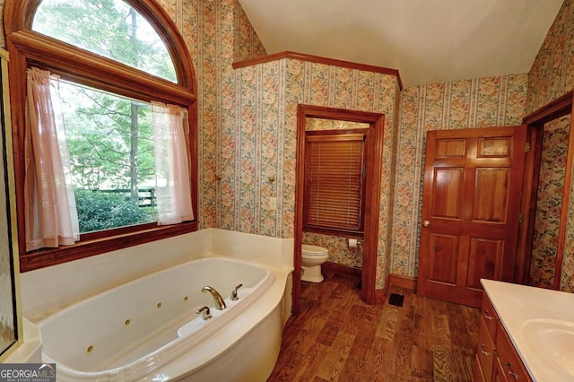 4393 Cannon Rd, Loganville, GA 30052 - full bath with wallpapered walls, wood finished floors, a jetted tub, and vanity