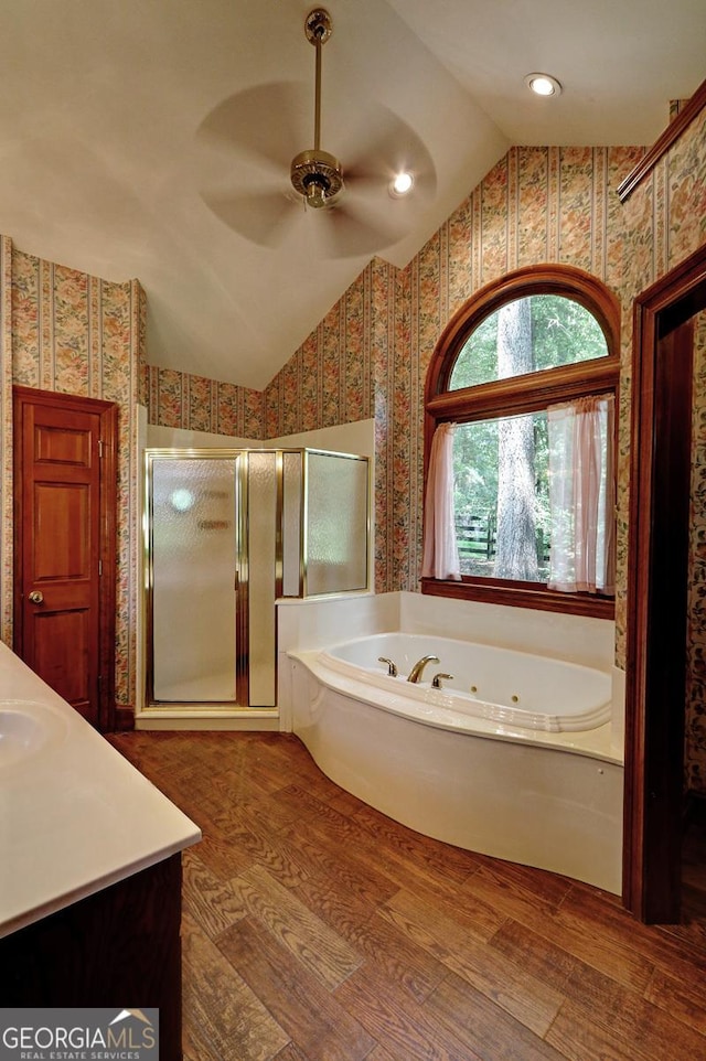 4393 Cannon Rd, Loganville, GA 30052 - full bath featuring wallpapered walls, a shower stall, a whirlpool tub, vaulted ceiling, and wood finished floors