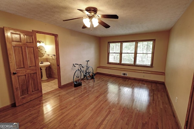 4393 Cannon Rd, Loganville, GA 30052 - unfurnished room featuring a textured ceiling, light wood-style flooring, and ceiling fan