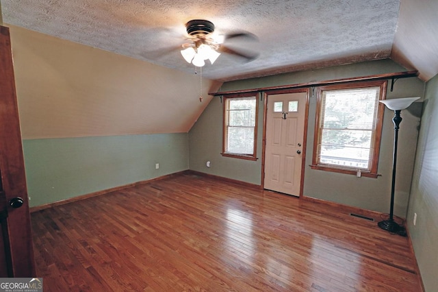 4393 Cannon Rd, Loganville, GA 30052 - additional living space with a ceiling fan, vaulted ceiling, hardwood / wood-style flooring, and a textured ceiling