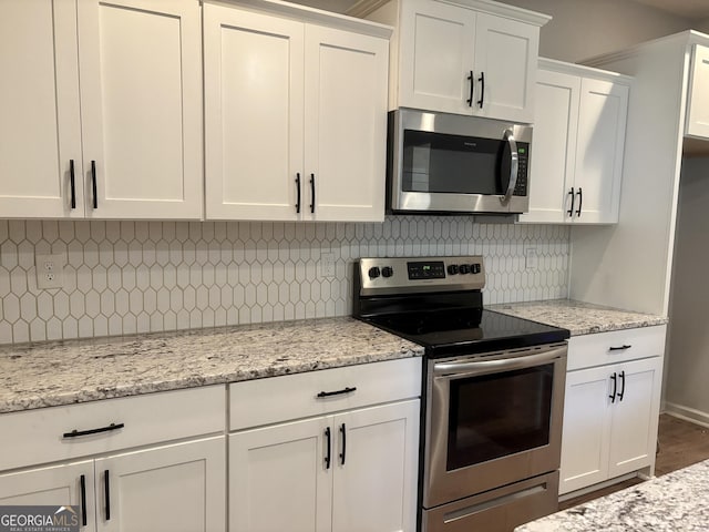 248 Webster Lake Dr, Temple, GA 30179 - kitchen with stainless steel appliances, white cabinetry, decorative backsplash, and light stone countertops