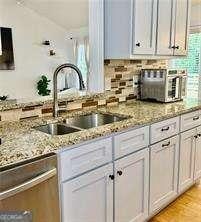 507 Legacy Park Ln, Powder Springs, GA 30127 - kitchen featuring stainless steel dishwasher, light stone counters, and decorative backsplash