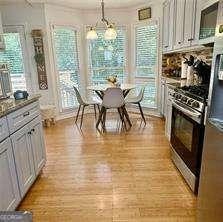 507 Legacy Park Ln, Powder Springs, GA 30127 - kitchen featuring gas stove, light wood-type flooring, hanging light fixtures, and fridge