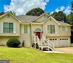 507 Legacy Park Ln, Powder Springs, GA 30127 - bi-level home featuring an attached garage, driveway, and a front lawn