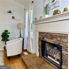 507 Legacy Park Ln, Powder Springs, GA 30127 - sitting room featuring a stone fireplace and dark wood finished floors