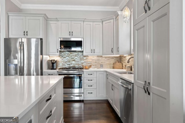 202 Jackson Rd SE, Milledgeville, GA 31061 - kitchen featuring stainless steel appliances, light countertops, backsplash, white cabinets, and ornamental molding