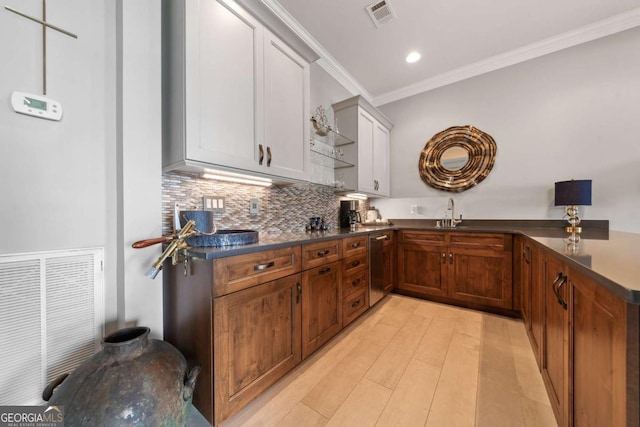 202 Jackson Rd SE, Milledgeville, GA 31061 - kitchen featuring dark countertops, ornamental molding, tasteful backsplash, stainless steel dishwasher, and light wood-style floors