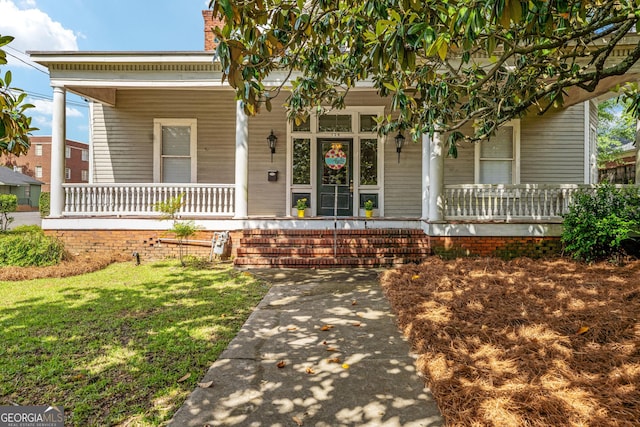 124 Hines Ter, Macon, GA 31204 - view of front of property with covered porch, a front yard, and a chimney