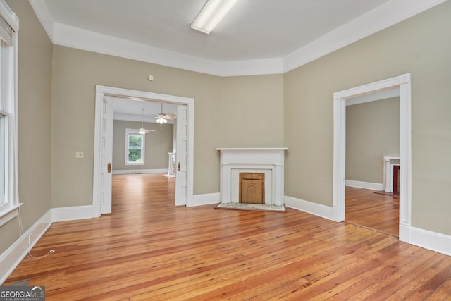 124 Hines Ter, Macon, GA 31204 - unfurnished living room featuring light wood-style floors, a fireplace with raised hearth, and a ceiling fan