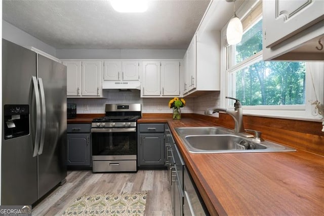 86 Kelly, Dallas, GA 30157 - kitchen with stainless steel appliances, wood counters, gray cabinetry, under cabinet range hood, and light wood-style flooring