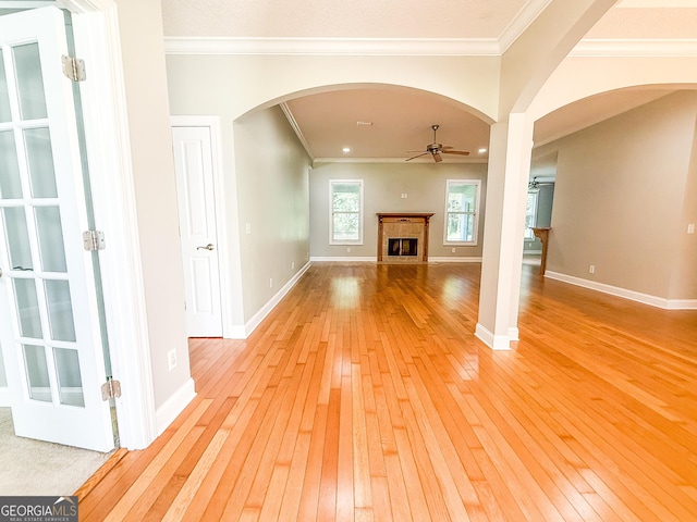152 Huron Loop, Brunswick, GA 31523 - unfurnished living room with arched walkways, a ceiling fan, light wood finished floors, ornamental molding, and a fireplace