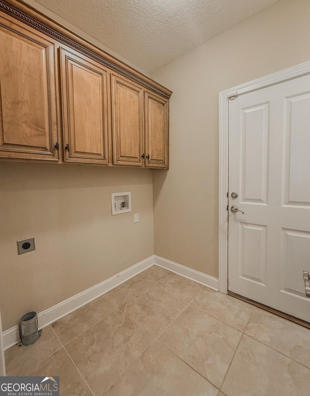 152 Huron Loop, Brunswick, GA 31523 - laundry area with hookup for an electric dryer, cabinet space, washer hookup, light tile patterned floors, and a textured ceiling