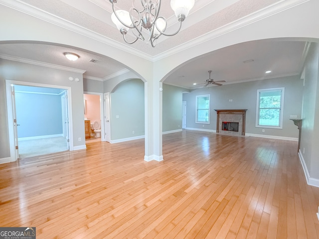 152 Huron Loop, Brunswick, GA 31523 - unfurnished living room featuring light wood finished floors, a chandelier, arched walkways, a fireplace, and a ceiling fan