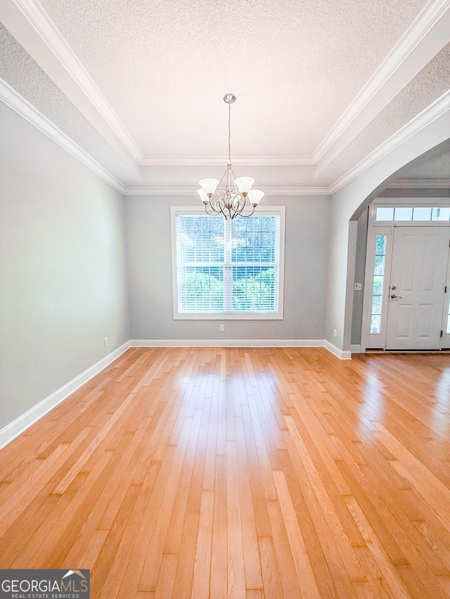 152 Huron Loop, Brunswick, GA 31523 - spare room with light wood finished floors, healthy amount of natural light, arched walkways, a chandelier, and a textured ceiling