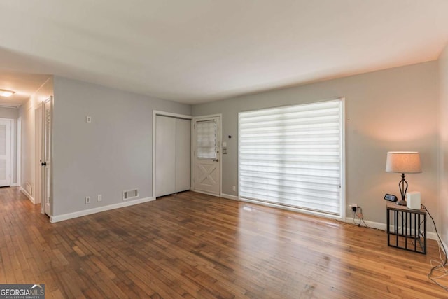 1784 Treymire Ct, Stone Mountain, GA 30088 - unfurnished living room with baseboards and wood-type flooring