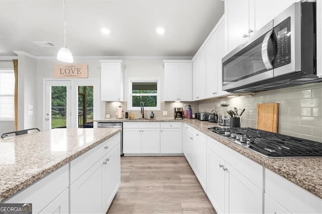 349 Garnet Dr, Acworth, GA 30101 - kitchen with appliances with stainless steel finishes, crown molding, white cabinetry, decorative backsplash, and light wood-style flooring