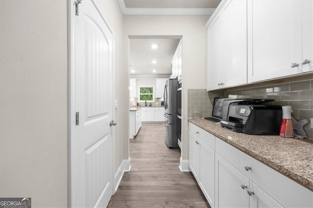 349 Garnet Dr, Acworth, GA 30101 - kitchen featuring freestanding refrigerator, ornamental molding, wood finished floors, white cabinetry, and backsplash