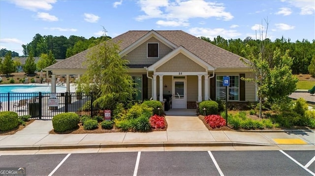 349 Garnet Dr, Acworth, GA 30101 - view of front of property with a community pool, uncovered parking, roof with shingles, and stone siding