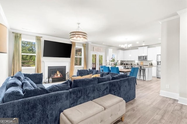 349 Garnet Dr, Acworth, GA 30101 - living area featuring a chandelier, crown molding, light wood-style flooring, a lit fireplace, and recessed lighting