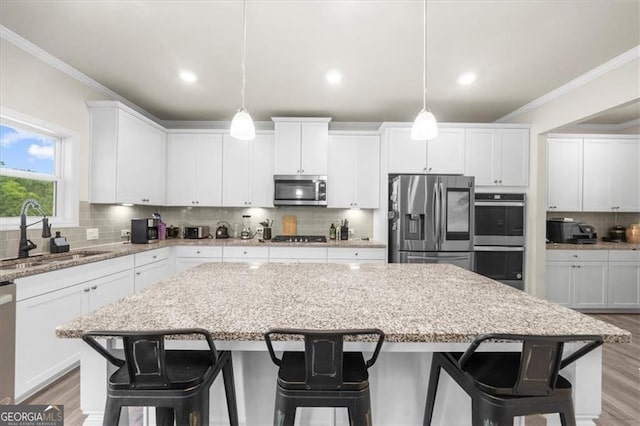 349 Garnet Dr, Acworth, GA 30101 - kitchen featuring stainless steel appliances, crown molding, a center island, backsplash, and white cabinets