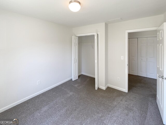 651 Walnut Woods Dr, Braselton, GA 30517 - unfurnished bedroom featuring dark carpet and a closet