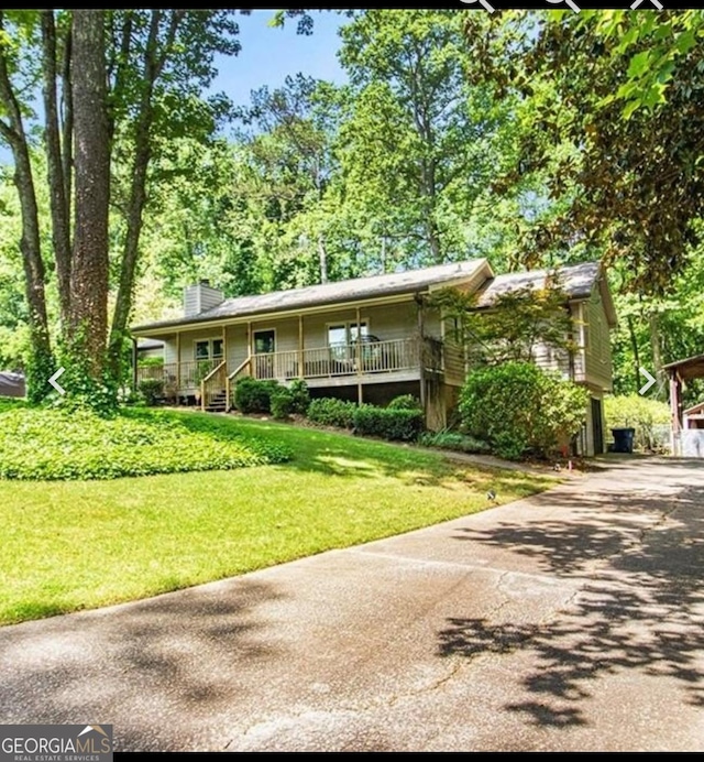 4352 Treeline Way, Douglasville, GA 30135 - view of front of house featuring covered porch, a chimney, a front lawn, and asphalt driveway