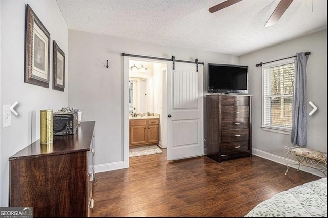 4352 Treeline Way, Douglasville, GA 30135 - bedroom with dark wood-style flooring, a barn door, a textured ceiling, and ensuite bathroom
