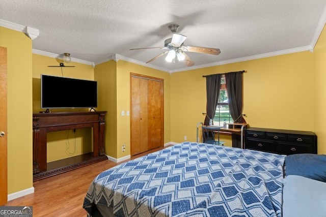 310 Ridge Rd, Kingsland, GA 31548 - bedroom with wood finished floors, ornamental molding, a closet, a textured ceiling, and a ceiling fan