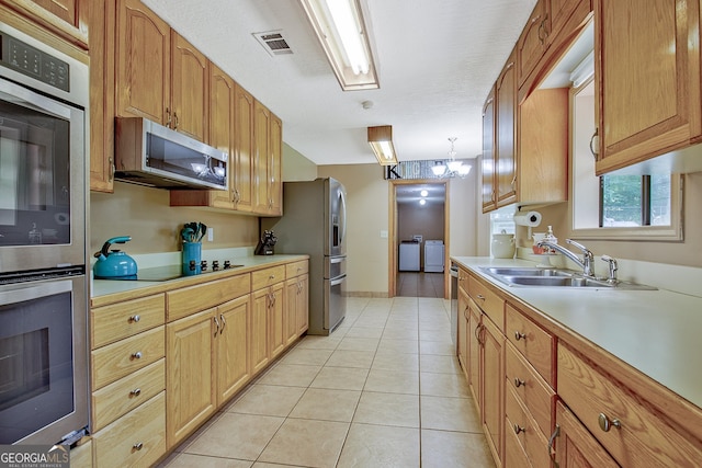 351 Weldon Rd, Palmetto, GA 30268 - kitchen featuring appliances with stainless steel finishes, washing machine and dryer, light tile patterned floors, and light countertops