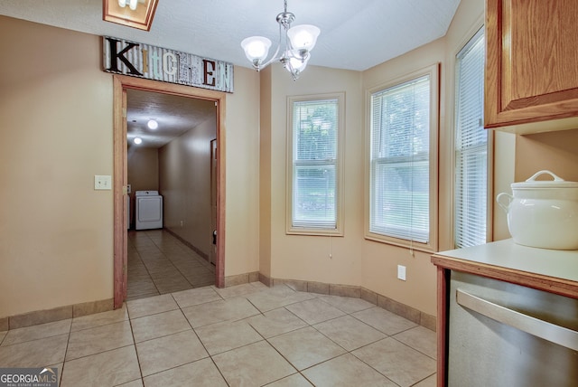 351 Weldon Rd, Palmetto, GA 30268 - unfurnished dining area with washer / clothes dryer, light tile patterned flooring, and a chandelier