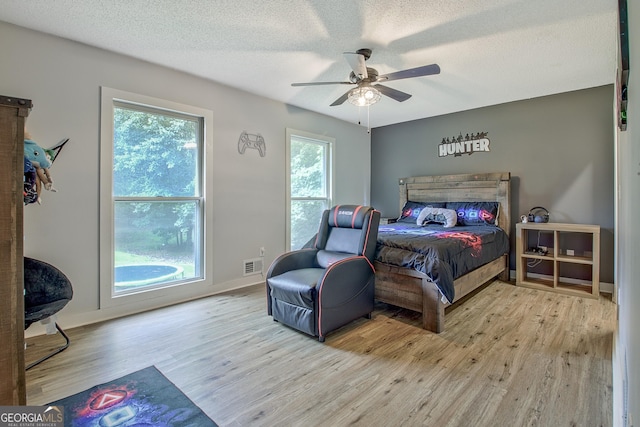 351 Weldon Rd, Palmetto, GA 30268 - bedroom featuring wood finished floors, multiple windows, ceiling fan, and a textured ceiling