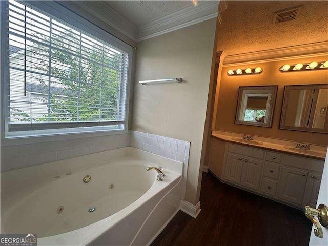 4189 Duncan Ives Dr, Buford, GA 30519 - bathroom with ornamental molding, a tub with jets, vanity, and wood finished floors