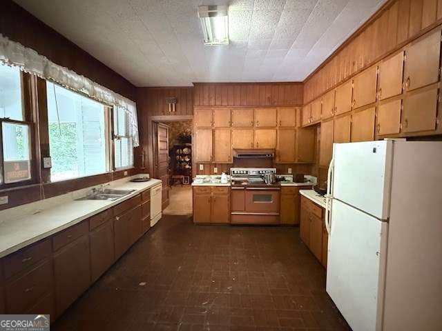 2205 Wilson Ave, Tifton, GA 31794 - kitchen with white appliances, under cabinet range hood, wood walls, and light countertops