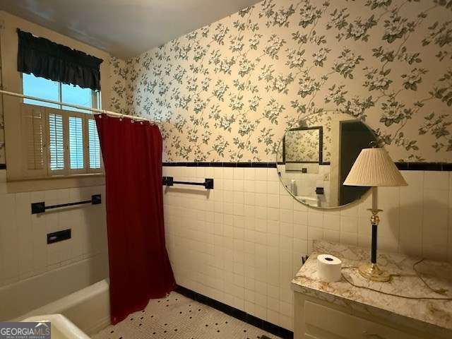 2205 Wilson Ave, Tifton, GA 31794 - full bath featuring wallpapered walls, a wainscoted wall, tile walls, vanity, and shower / tub combo with curtain