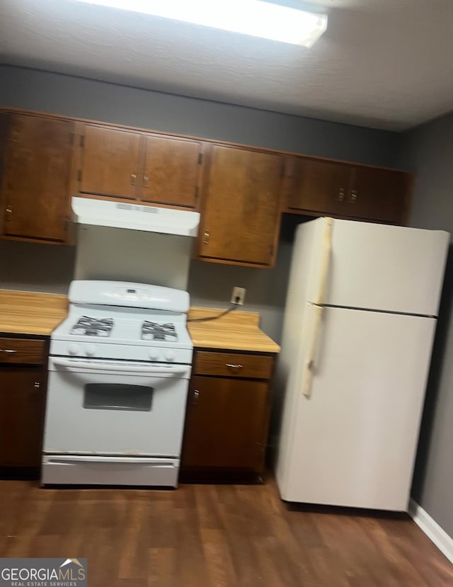 6470 Bedford Ln, Lithonia, GA 30058 - kitchen featuring white appliances, under cabinet range hood, light countertops, and dark wood-style floors