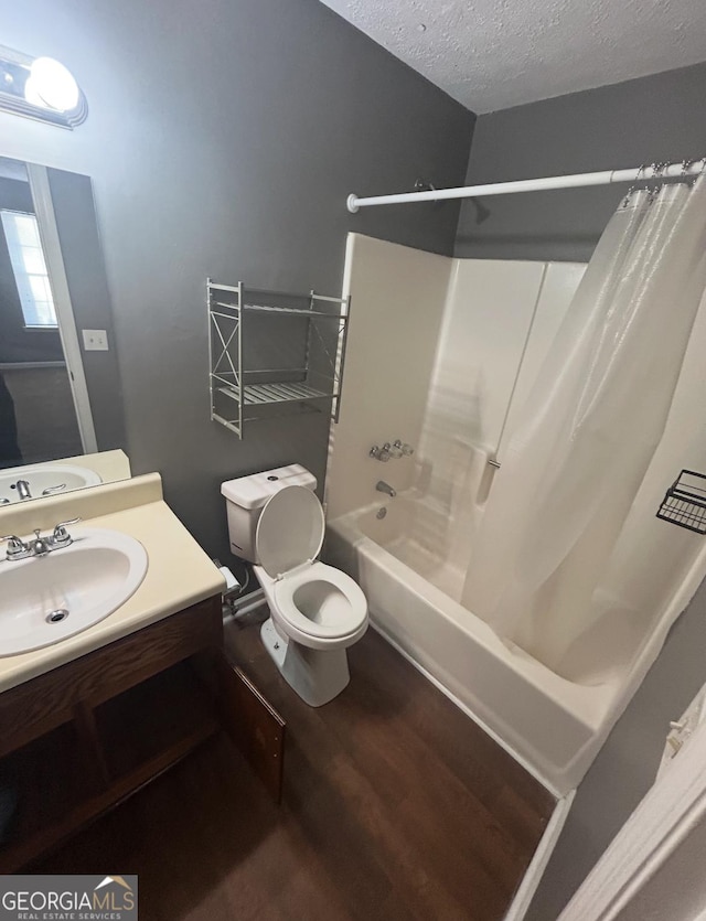 6470 Bedford Ln, Lithonia, GA 30058 - full bathroom featuring shower / bath combo with shower curtain, vanity, wood finished floors, and a textured ceiling