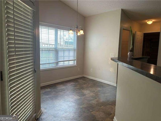 1241 Key Manor Ln, Lawrenceville, GA 30045 - unfurnished dining area featuring a chandelier, a textured ceiling, and vaulted ceiling