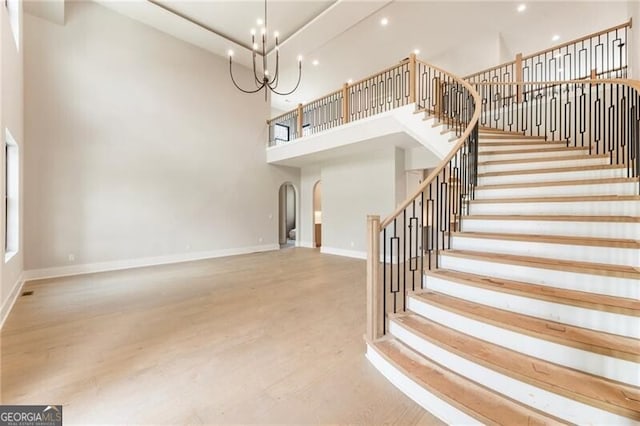 15792 Thompson Rd, Milton, GA 30004 - stairs with a towering ceiling, wood finished floors, arched walkways, a chandelier, and recessed lighting