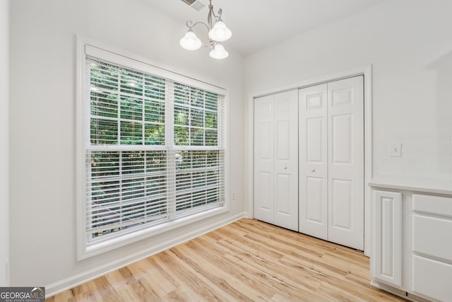384 Daniel Mill Xing, Villa Rica, GA 30180 - unfurnished bedroom featuring a chandelier, light wood-style flooring, and a closet