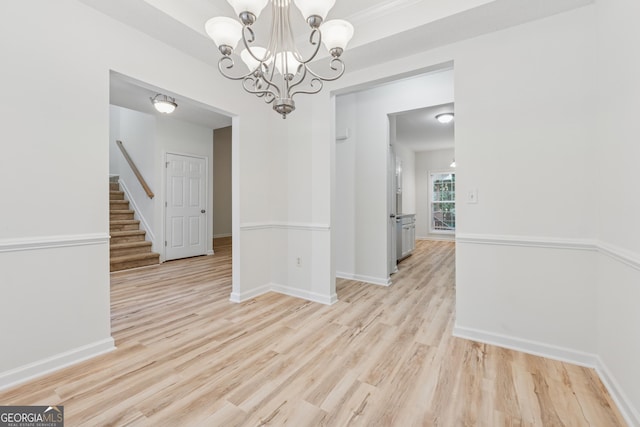 384 Daniel Mill Xing, Villa Rica, GA 30180 - spare room featuring light wood-style floors, stairway, and a chandelier