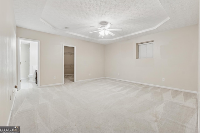 384 Daniel Mill Xing, Villa Rica, GA 30180 - unfurnished bedroom featuring a textured ceiling, a raised ceiling, light carpet, a spacious closet, and a closet