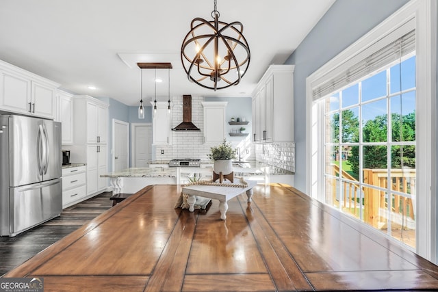 106 Big Cotton Trl, Mcdonough, GA 30252 - kitchen with freestanding refrigerator, wall chimney range hood, tasteful backsplash, a chandelier, and white cabinets