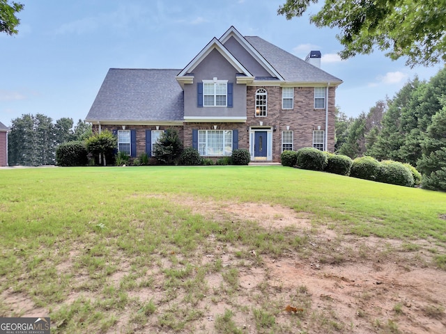 106 Big Cotton Trl, Mcdonough, GA 30252 - view of front of home featuring a front yard, a chimney, stucco siding, and brick siding