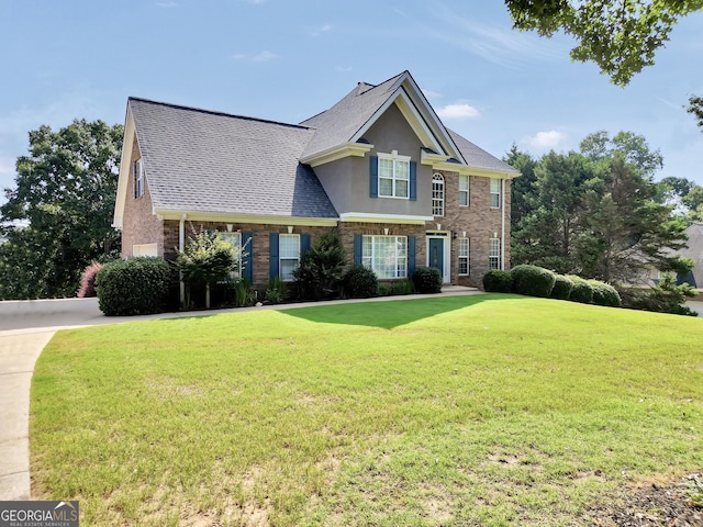 106 Big Cotton Trl, Mcdonough, GA 30252 - view of front of house with a front lawn, brick siding, stucco siding, and roof with shingles