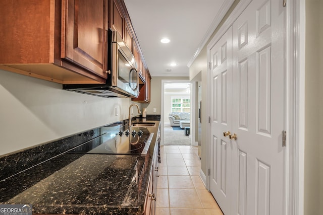 106 Big Cotton Trl, Mcdonough, GA 30252 - kitchen with ornamental molding, black electric cooktop, light tile patterned floors, stainless steel microwave, and dark stone countertops