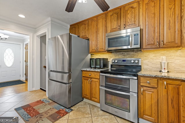 2421 Pittman Cir, Cumming, GA 30040 - kitchen with stainless steel appliances, light tile patterned floors, brown cabinetry, and crown molding